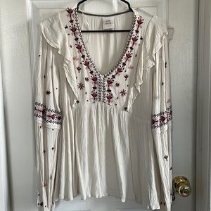 Long sleeve flowy v-neck blouse with embroidery detail.